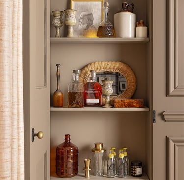 a cabinet with a shelf full of bottles and bottles