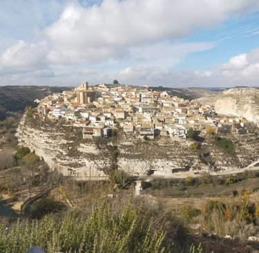 a small town on a hill with a river running through it