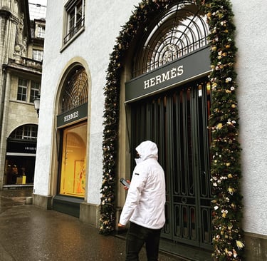 Male model in white coat walks along the Hermes store in Munich, Germany @LVF.LVX