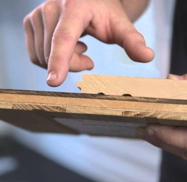 Professional guiding and showing the difference between solid and engineered hardwood boards.