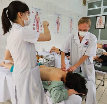 Professional acupuncturists in a clinic performing traditional acupuncture therapy on a patient's back.