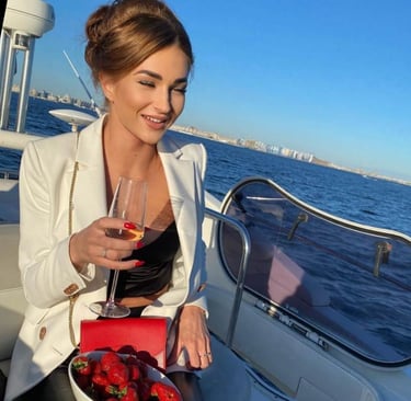 femme sur bateau tient un verre de vin
