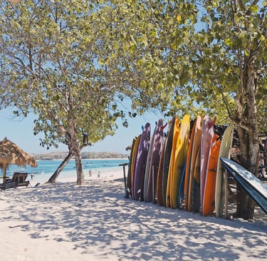 Colorful surfboards lined up on the sandy shores of Tanjung Aan Beach, Lombok, vibrant atmosphere at Paradise Surf School