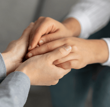 a woman holding a man's hand while he is holding his hand while communicating