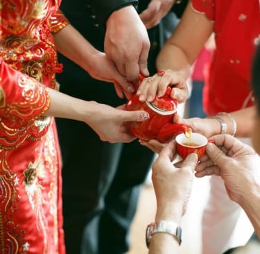 a man and woman holding a red teapot