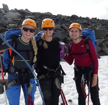 three female climbers standing standing in the snow