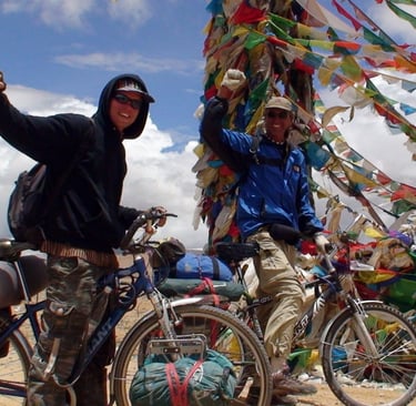 two cyclists at a Tibetan pass