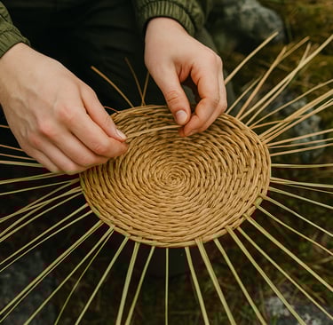 Close-up of survival basket weaving using natural materials, wilderness bushcraft skill for carrying and trapping