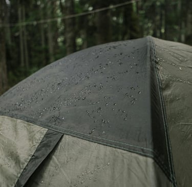 Rain on tent in forest, highlighting waterproofing, shelter durability, and survival gear use