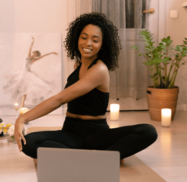 a woman sitting on a yoga mat with candles and candles engaging in virtual physiotherapy exercises