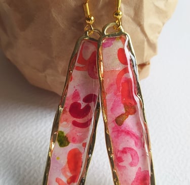 a pair of earrings with a pink flower