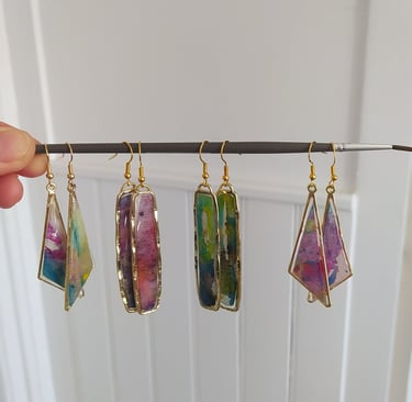 a person holding a string of jewelry with a bunch of colorful gems