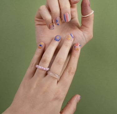 les mains d'une femme avec des bagues et du vernis sur les ongles