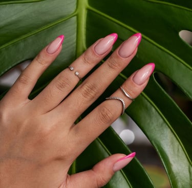 la main d'une femme avec des bagues et du vernis sur les ongles
