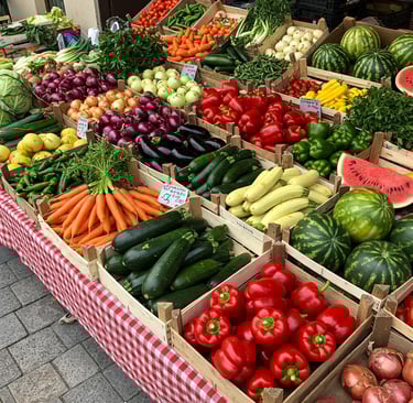 A vibrant market stall displays a variety of fresh produce. There are wooden crates filled with veg