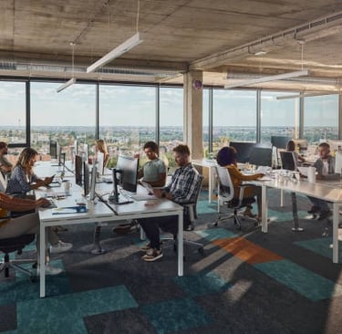Entorno de oficina, personas trabajando frente a computadoras.