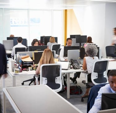 personas trabajando en escritorios en una oficina