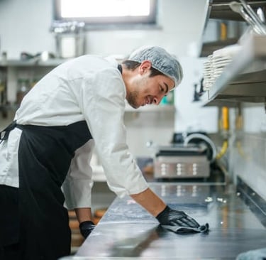 Chef sonriente limpiando la encimera de la cocina