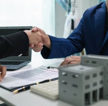 Apretón de manos de negocios sobre la mesa, computadora portátil sobre la mesa