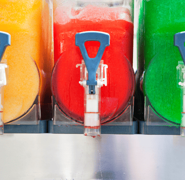 a bunch of different colored drinks in a row