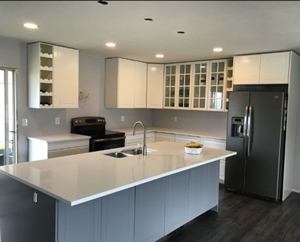 Two-tone RTA kitchen in Kelowna, navy base cabinets, white shaker uppers and a quartz island sinksin