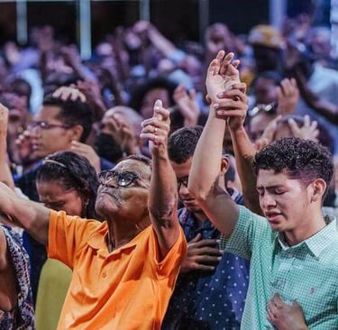 Congregation worshiping together with raised hands, expressing faith and devotion.
