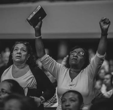 People worshiping with raised hands, expressing praise and reverence.