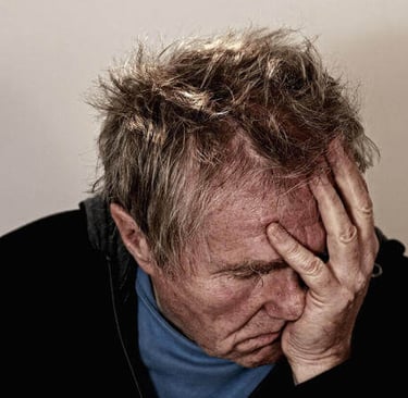 a man with a beard and a blue shirt in torment