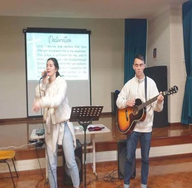 Ministry team leading worship with singing and guitar during a church gathering.