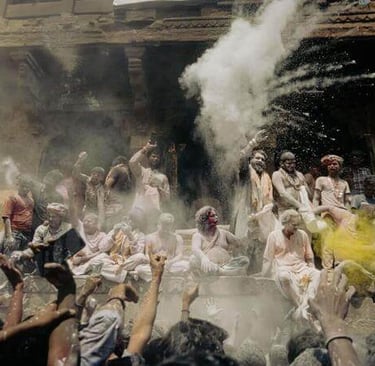 religious celebration - a group of people standing around a large pot and throwing dust