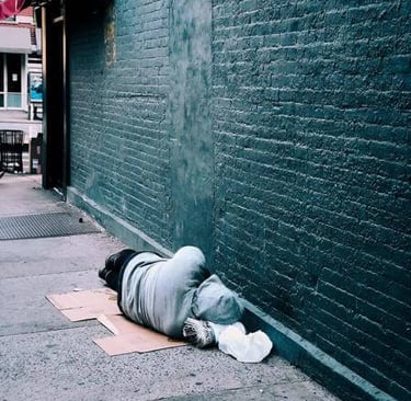 a person laying on the ground in front of a building
