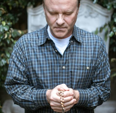 a man holding a rosary and a rosary