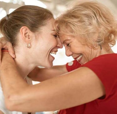 a woman in a red shirt is hugging her mother