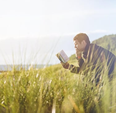 a man sitting on a bench reading a bible