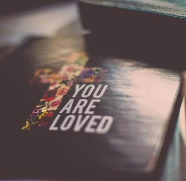 Book with the words “You are loved” on the cover.