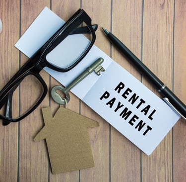 Rental payment text on notepad with house model and key on wooden desk