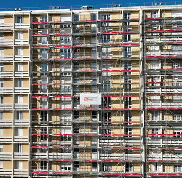 Multi-story apartment building renovation with metal scaffolding for exterior facade construction.