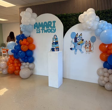 a party with bluey decor and a balloon arch