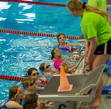 coach instructing kids swimming
