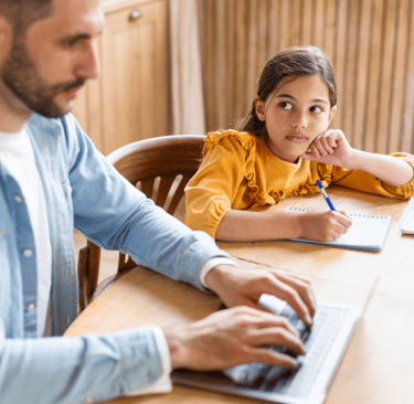 Father on computer with daughter waiting beside him, symbolizing ADHD hyperfocus and time blindness