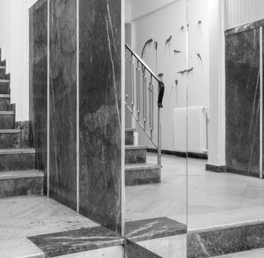 A staircase leading to a staircase in a building with paint smudges on the walls and floor