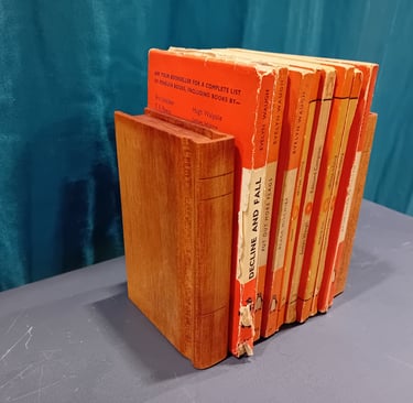 Pail of book-shaped wooden bookends around a set of orange books