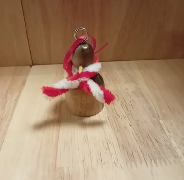 Penguin hanging Christmas decoration in dark wood with light wood tummy and pipecleaner scarf