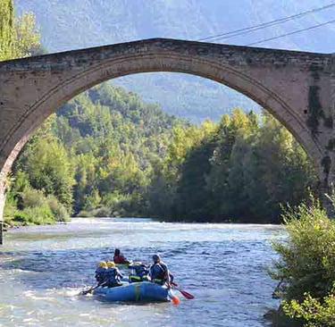 a group of people rafting down a river in sort