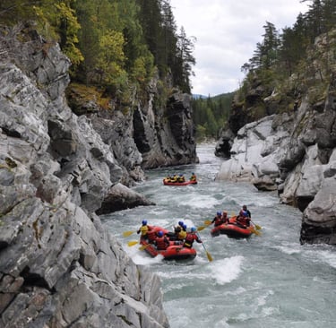 a group of people rafting down a river in norway