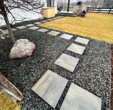 BlueMoon Pathway leading toward Patio- 1 1/2 inch black Granite rock surrounding pathway.