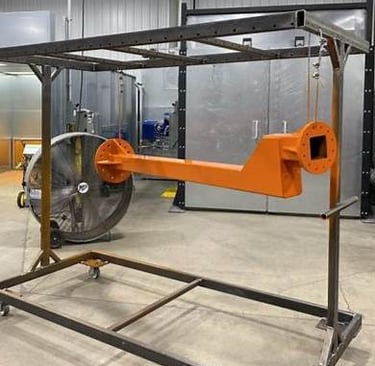 A rack mid‑way through powder‑coating preparation