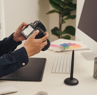 a man sitting at a desk with a camera ready to design