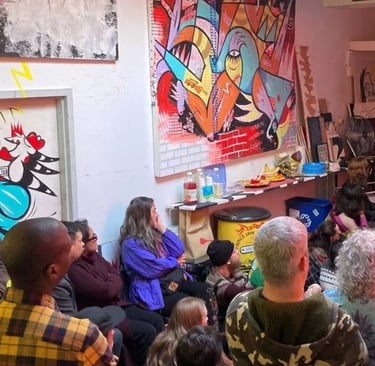 A diverse crowd attends an art gallery exhibition featuring vibrant abstract paintings and street art.