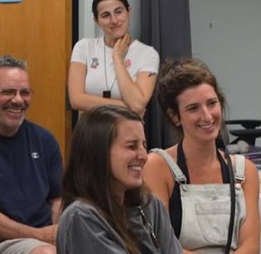Diverse group of smiling colleagues enjoying a collaborative team meeting in a casual office setting.